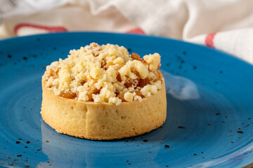 Freshly baked single portion apple pie on a blue porcelain plate