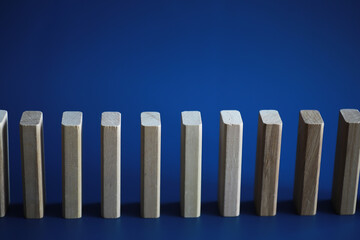 Closeup thick domino wood block in a row stop the falling, be stable in crisis, business solution concept