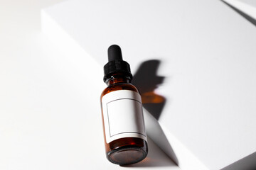 Glass dropper bottles with pipette on the podium with shadow on white background. Beauty cometic product advertising, mocke up.Copy space..