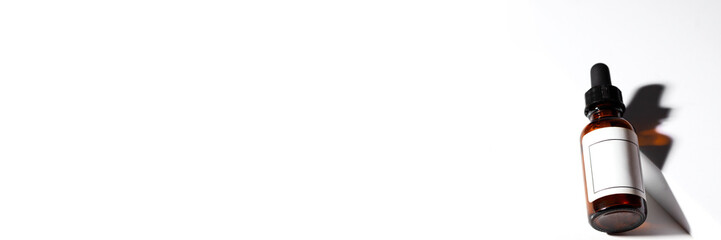 Amber dropper bottle with black pipette on the podium with shadow  and reflection on white background. Beauty cometic banner..