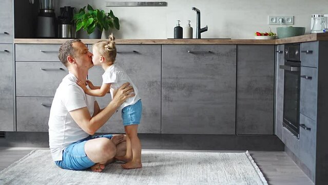 A happy father and little girl joyfully spending time in a modern kitchen. Happy family. Father's day.