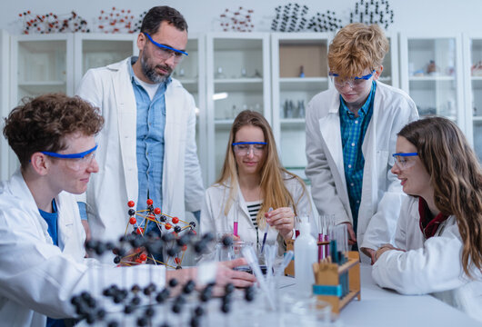 Science students with teacher doing chemical reaction experiment in the laboratory at university. Low angle view.