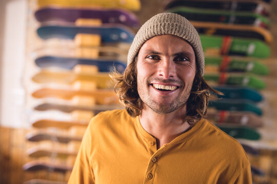 Image of happy caucasian man posing in skate shop