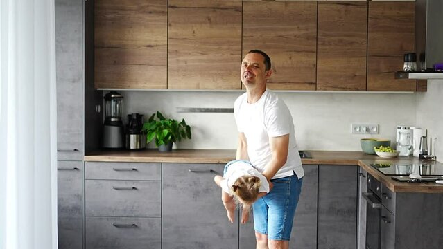 A happy father and little girl joyfully spending time in a modern kitchen. Happy family. Father's day.
