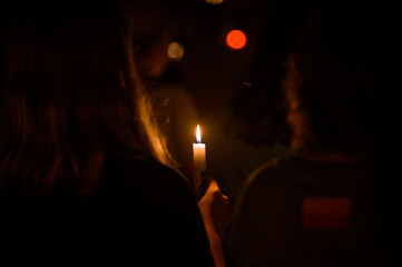 Naklejka premium People holding candles during the veneration of the Holy Cross after the Holy Mass during Mladifest (Youth Festival) in Medjugorje, Bosnia and Herzegovina. 2021/08/02.