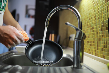 Man washing dish in sink at restaurant.People are washing the dishes too Cleaning solution