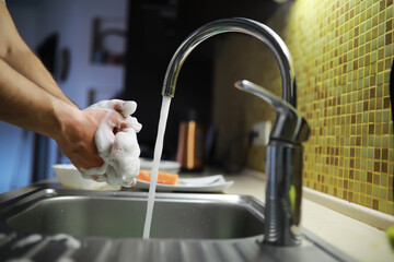 Man washing dish in sink at restaurant.People are washing the dishes too Cleaning solution