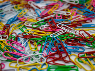 close up selective focus of colorful paperclip as a background and texture with white background in...
