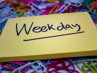 close-up selected focus yellow sticky notes with weekday underlined written on it or weekday...