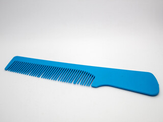 close up selective focus of blue hair comb isolated on white background