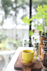 yellow coffee cup and laptop and white flowers on white table indoor work from home