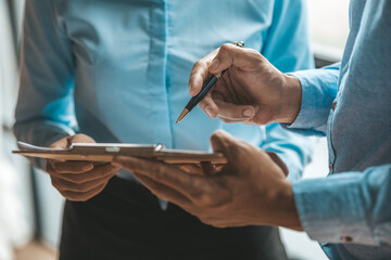 Company meeting room has businessmen and finance managers meeting together on finance topics, they are looking at information on documents and discussing together. Concept company financial management