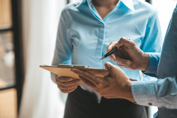 Company meeting room has businessmen and finance managers meeting together on finance topics, they are looking at information on documents and discussing together. Concept company financial management