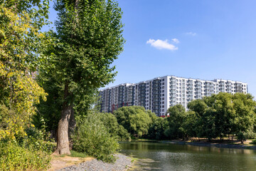 Fototapeta na wymiar New modern residential apartment building near the lake surrounded by green trees