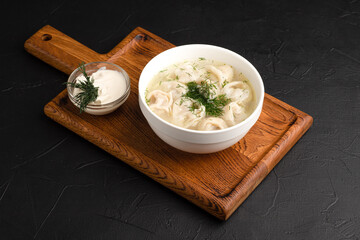 soup with dumplings, soup with sour cream, side view black background