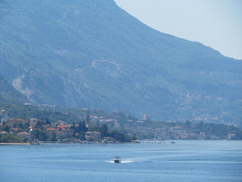 boat in front of city in bay of kotor