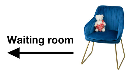 Sign to waiting room with arrow to the left and a teddy bear with a heart sitting on a blue chair...