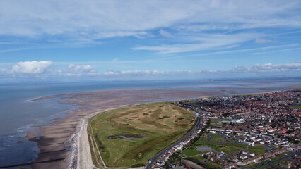 Aerial view of the coast with  sea and blue sky and buildings and houses. Taken in Fleetwood Lancashire England. 