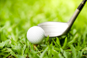 golf club hitting a golf ball on green grass