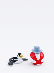 Inflatable penguin and beach ball with hat on white background in summer season. 3D rendering, 3D illustration