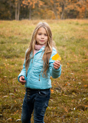 beautiful girl with long blonde hair having fun in autumn park