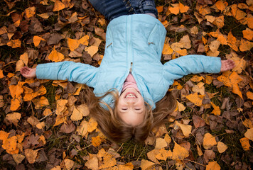 beautiful girl with long blonde hair having fun in autumn park