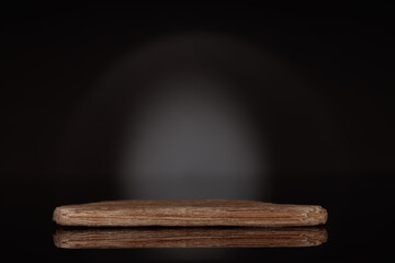 MOCK-UP, wooden podium to show packaging and product on dark black background, copy-space.