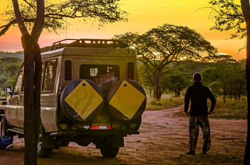 Adventurer or tourist and his 4x4 contemplating the sunset on the African savannah © Image'in