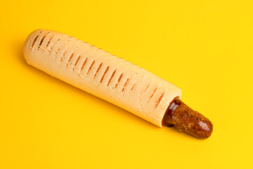 french hot dog, yellow background side view