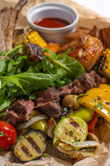 meat with vegetables and sauces on a wooden desk .pork , lamb, chicken meat . Meat set