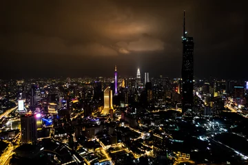 Zelfklevend Fotobehang Aerial photo of Kuala Lumpur capital of malaysia with all the lights on, city of light, in the middle of asia with several malls and giant buildings capital of business photo taken at night © Nicholas