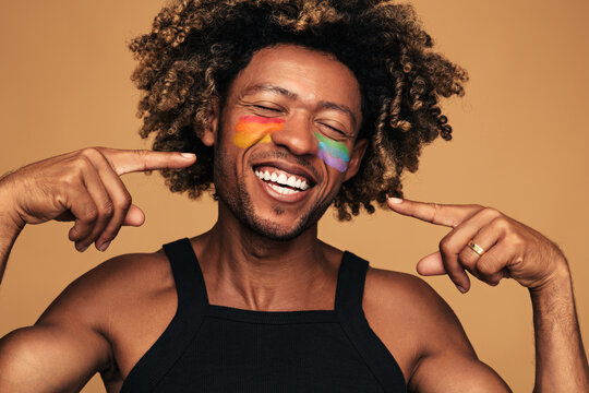 Cheerful African American gay pointing at face
