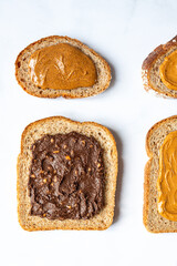Open sandwiches from various kind of wholegrain bread with different nut butter, such as peanut, crunchy cashew and almond butter