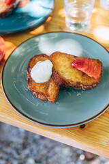 French toast with honey syrup, cream and strawberries