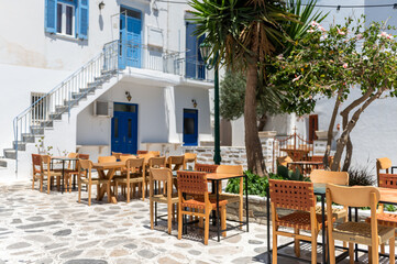 Fototapeta na wymiar City centre and streets of village of Tinos with Cycladic houses, cafe and shops on Tinos island, Cyclades, Greece