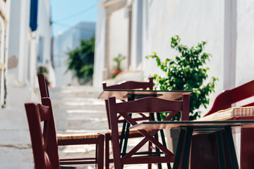 Empty cafe tables on streets of village of Pyrgos with Cycladic houses on Tinos island, Cyclades, Greece