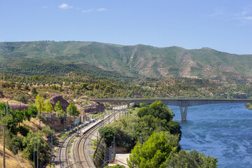 Train station, with the bridge crossing the river and the mountains in the background.