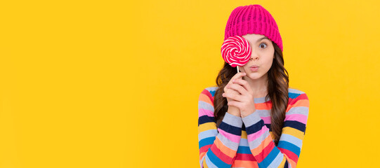 surprised teen girl hold lollipop. lollipop lady. hipster kid with colorful lollypop sugar candy. Teenager child with sweets, poster banner header, copy space. - obrazy, fototapety, plakaty