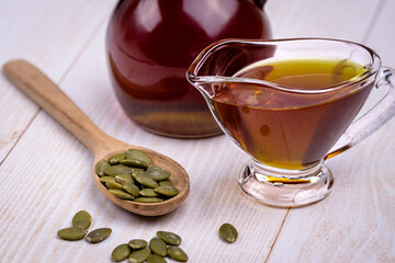 Pumpkin seed oil in a glass vessel and pumpkin seeds close-up, space for copying and selective...