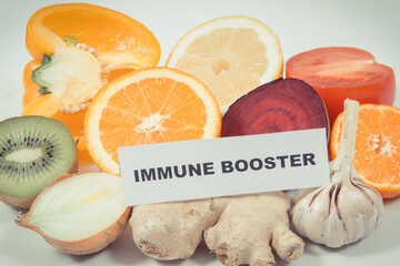 Inscription immune booster, fresh healthy fruits and vegetables containing vitamins. Immune boosting in times of Covid-19