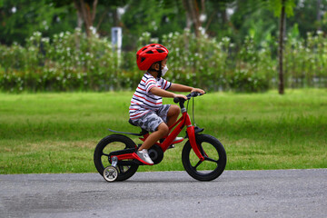 Asian Little boy riding a red bicycle