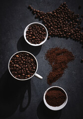 White cup of freshly brewed roasted coffee beans on gray background