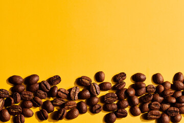 Roasted coffee beans on yellow background