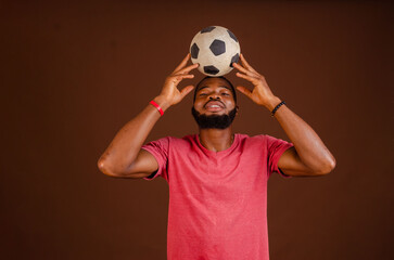 Screaming african american man 20s football fan in t-shirt isolated on brown background. Sport...