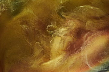 Liquid fluid art abstract background. Ocher yellow mix of dancing acrylic paints underwater, space...