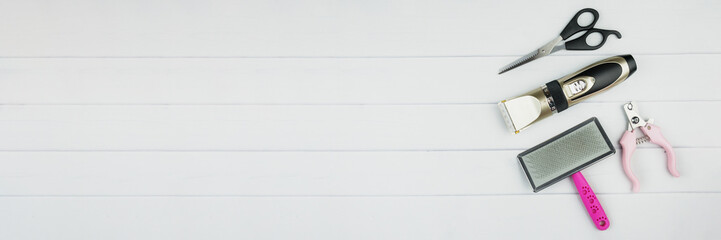 Set of tools for grooming: electric pet clipper, grooming scissors, wool brush and grooming scissors. Background with copy space on topic of pet care, Grooming, hygienic of cats and dogs. Top view