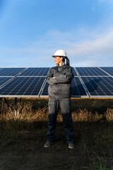 Charming happy woman in helmet with crossing hands near the energy batteries in the outside
