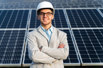 Handsome Caucasian entrepreneur standing in front of the energy farm in the countryside