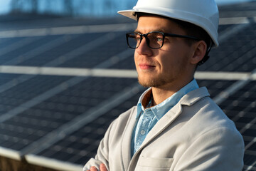 Elegant business man in glasses in front of the solar panel