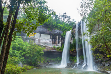 Waterfall in the deep forest. Huai Luang waterfall Huai Luang waterfall middle of the humid forest at Ubon Ratchathani, Thailand, Asia. Leaf moving low-speed shutter blur.